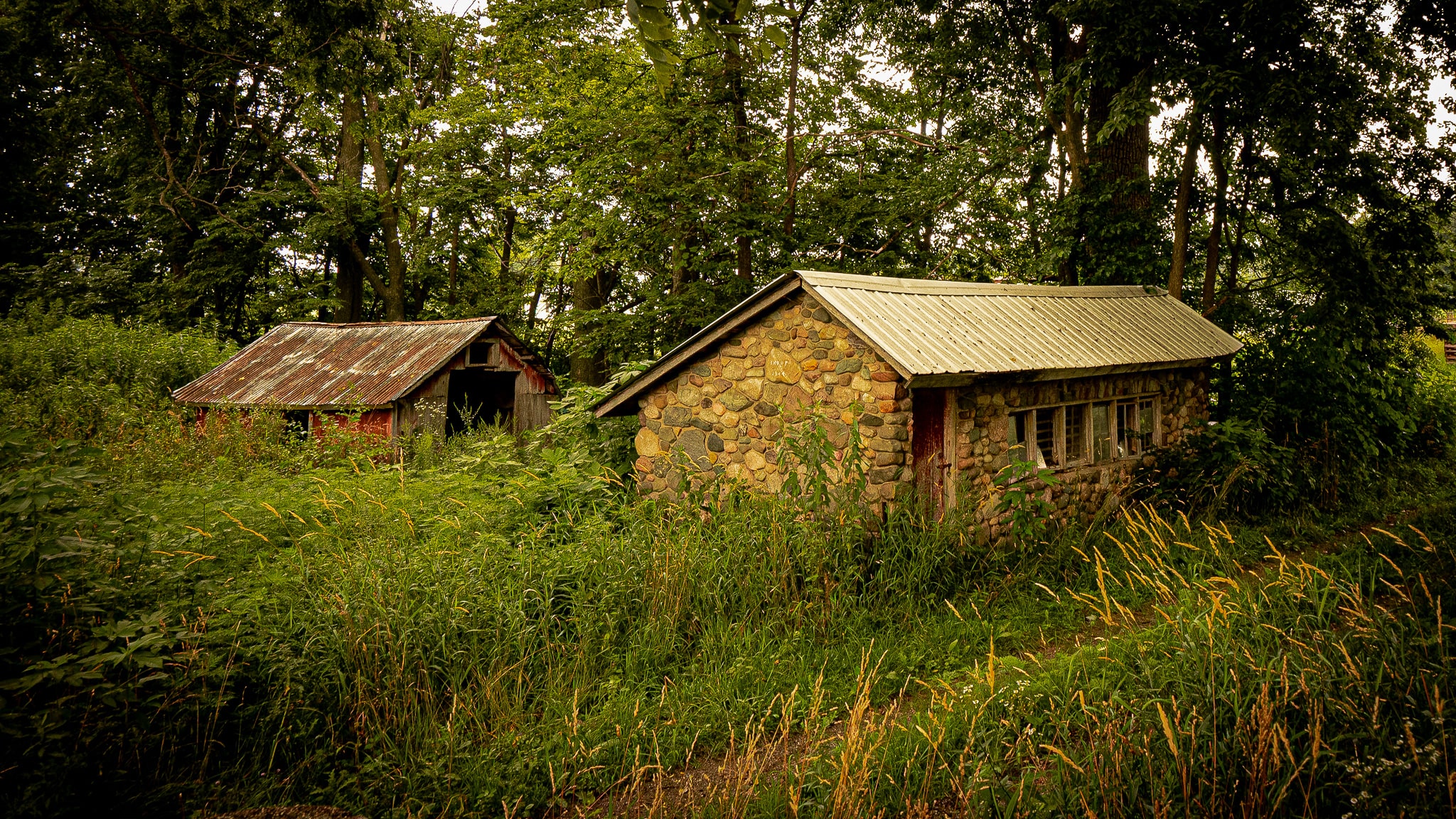 A rustic 80-year-old stone chicken coop & a rusty tin-sided shed