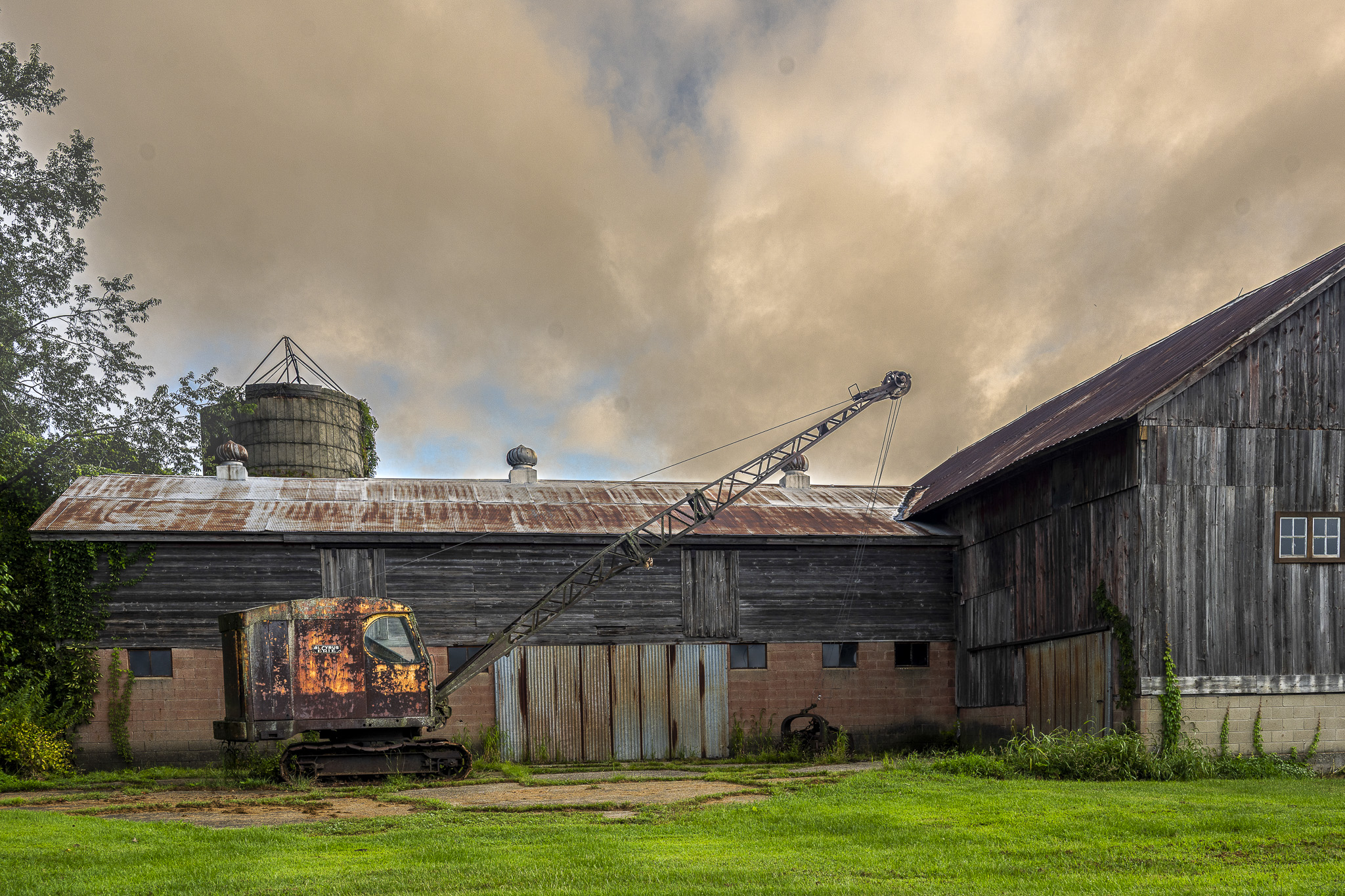 The weathered crane along the side of a rustic barn